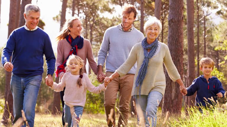 Three generations of a family hiking in forest